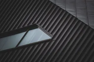 Stehfalzbahnen aus Metall mit eingesetztem Dachflächenfenster im Detail