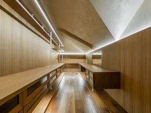 Einbauschrank unter Dachschräge mit raumhohen Holzfronten, Kleiderstangen und passgenauen Auszügen