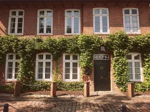 Verkauftes Objekt: efeubewachsenes Backsteinhaus mit Sprossenfenstern und Kopfsteinpflaster-Vorplatz