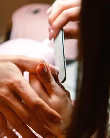 Nageldesignerin feilt die Kante eines Nagels in Nahaufnahme