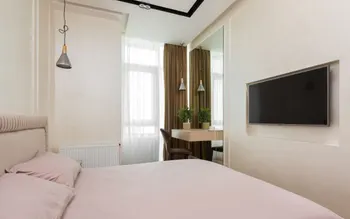 Doppelzimmer mit Tageslicht: breites Bett, Heizkörper unter dem Fenster, kleiner Schreibtisch mit Spiegel