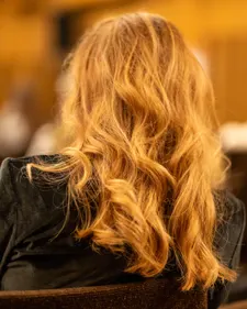 Balayage-Ergebnis von hinten: warmes Goldblond fällt in weichen Wellen
