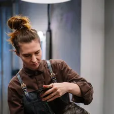 Friseurin schneidet konzentriert eine nasse Partie, Blick auf die Schere