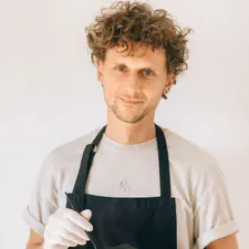 Colorist rührt die Farbmischung in der Schale an, Handschuhe und Schürze