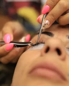 Nahaufnahme beim Setzen einer einzelnen Wimpernverlängerung mit Pinzette
