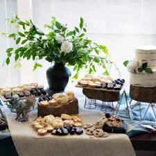 Dessert-Tisch mit Naked Cake, Tartelettes und Keksen auf Holzpodesten